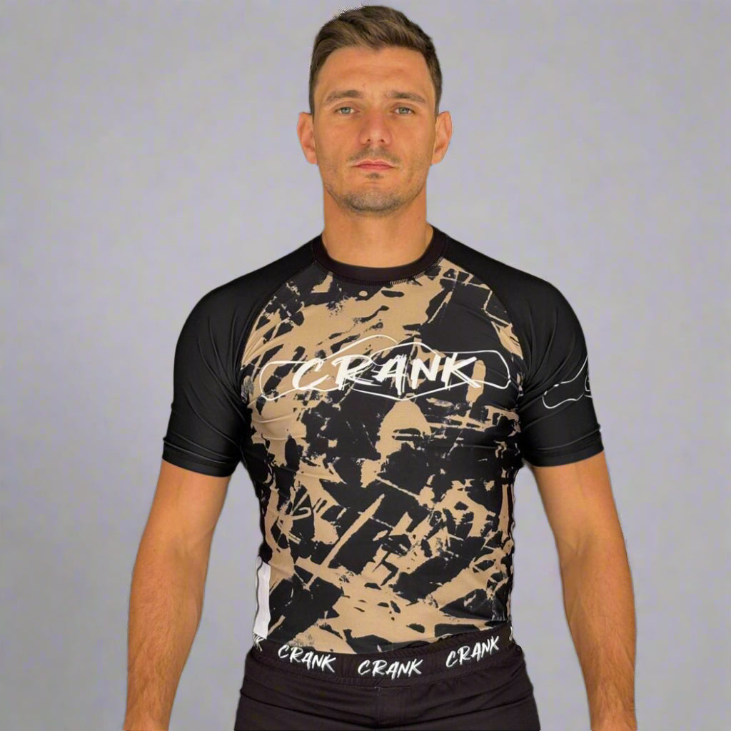 Man wearing a black and beige 'CRANK' branded shirt against a dark background