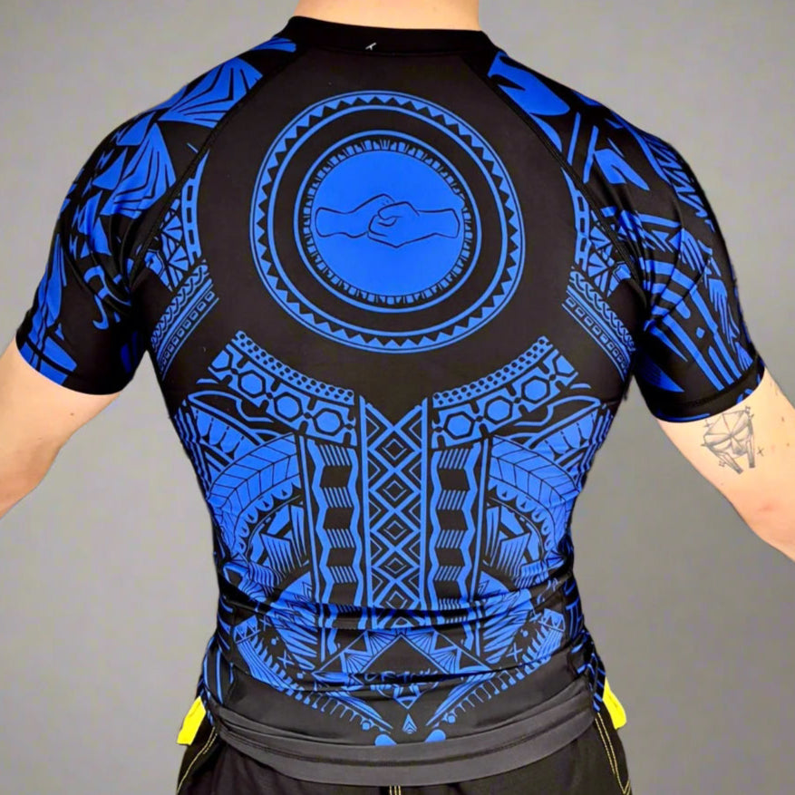 Person wearing a black and blue patterned shirt in a gym setting.