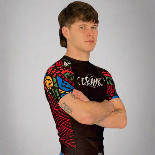 Person wearing a colorful athletic outfit with 'Crank' branding against a gray wall.